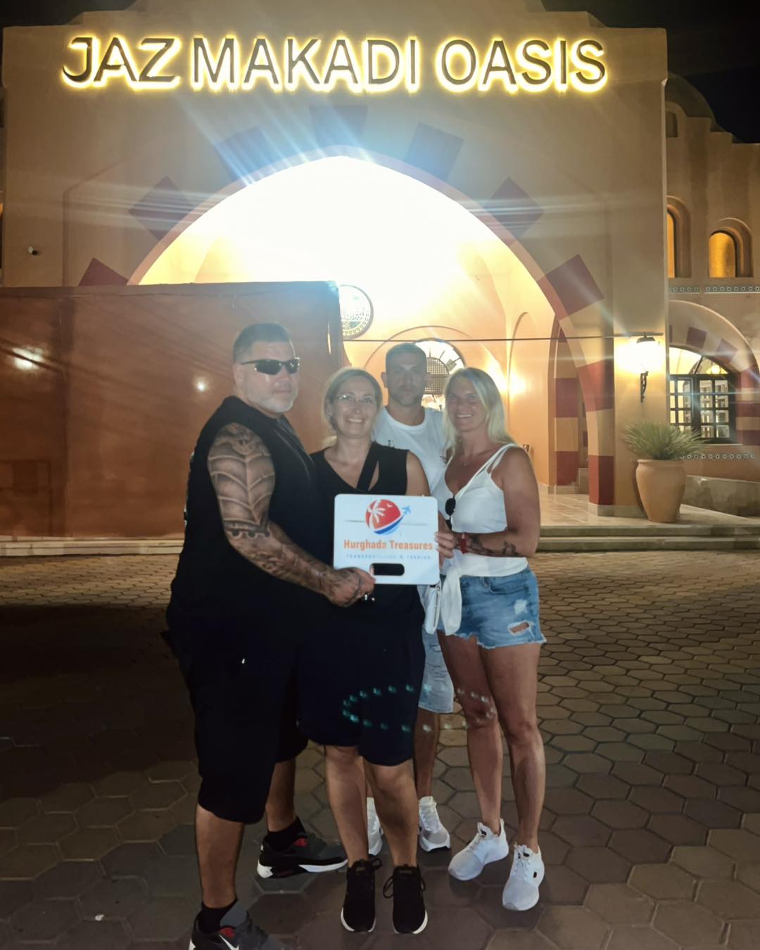 Guests with the Hurghada Treasures sign at Jaz Makadi Oasis Resort after a private transfer